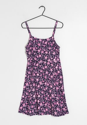 Robe sans manches bleu marine avec motif floral rose et violet clair, corsage cintré et jupe évasée accrochée à un cintre noir.