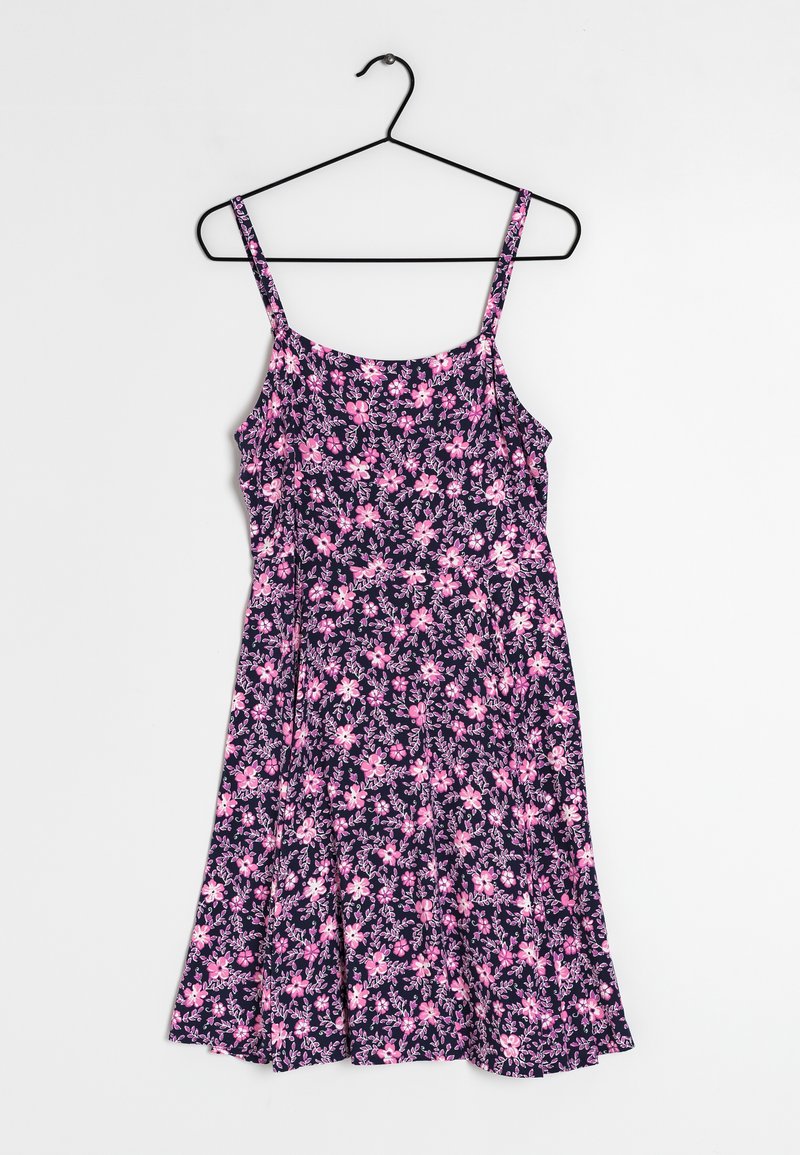 Robe sans manches bleu marine avec motif floral rose et violet clair, corsage cintré et jupe évasée accrochée à un cintre noir.
