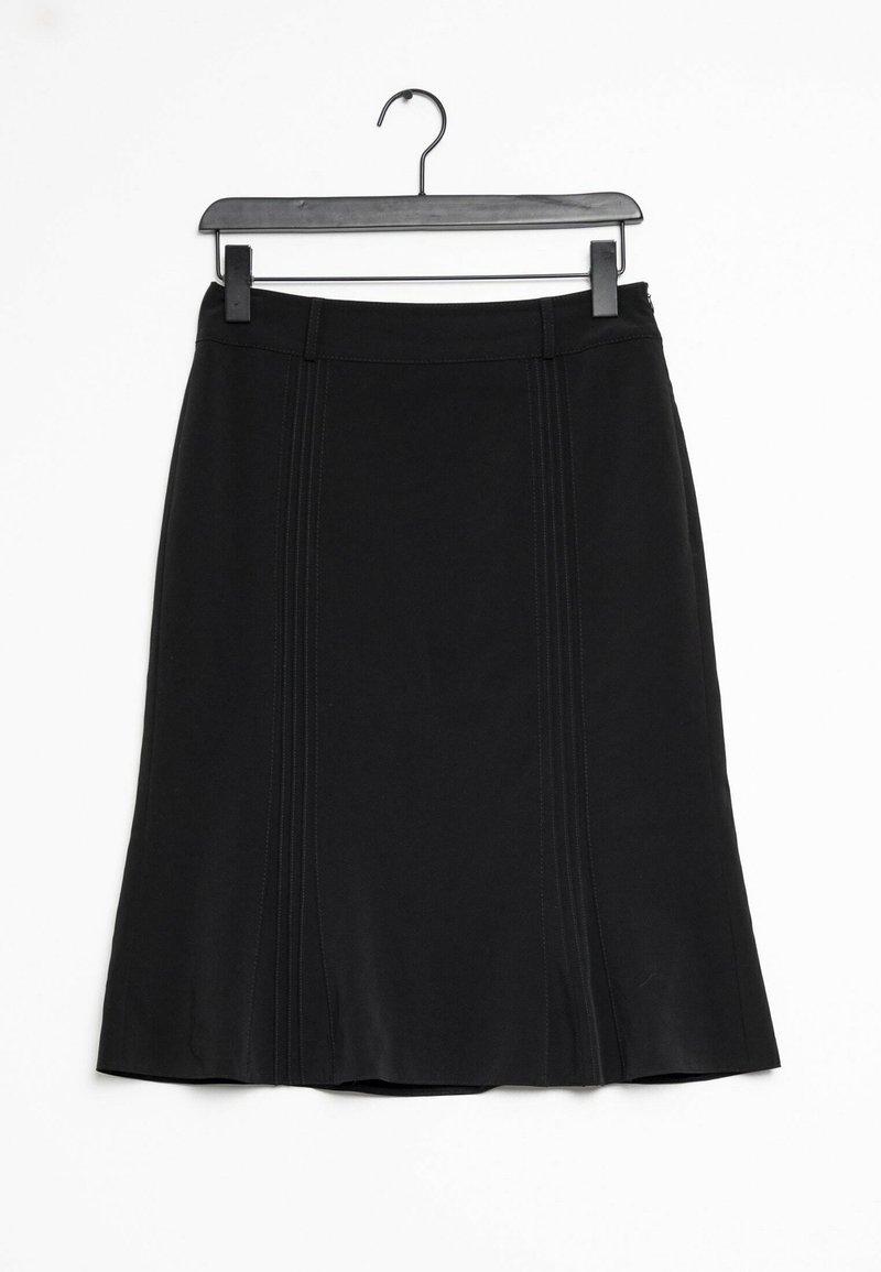 Jupe noire longueur genou avec détails de coutures verticales et passants de ceinture, suspendue sur un cintre en plastique noir sur fond blanc.