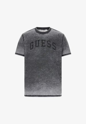 Grijs T-shirt met korte mouwen, voorzien van een vervaagde look, een ronde hals en een zwart bedrukt "GUESS"-logo over de borst.