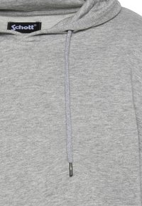 Szara bawełniana bluza z kapturem wykonana z teksturowanej tkaniny, z regulowanym sznurkiem zakończonym metalowym aglet oraz metką z logo przy dekolcie.