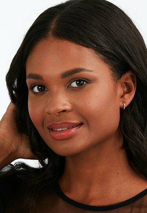 Ohrringe mit einem kleinen, runden Edelsteindetail, getragen von einer Person mit dunklem, lockigem Haar, glatter Haut und dezentem Make-up.