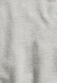 Hellgrauer Stoff mit dezenter Textur und weichen Falten, ähnlich wie Baumwolle oder eine Baumwollmischung.