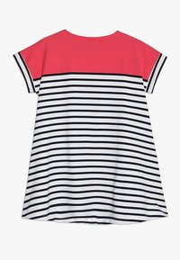 Pasiasta sukienka z górą w jednolitym różowym kolorze, z poziomymi czarno-białymi paskami. Krótkie rękawy i luźny, swobodny krój.