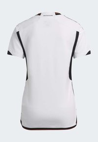 Jersey deportivo blanco de mangas cortas, con paneles laterales y acentos negros. En la parte posterior se muestra "DEUTSCHLAND" en el cuello. Textura de tela suave.