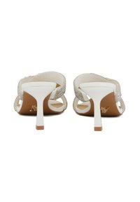 Sandali alti bianchi con cinturino decorato da cristalli, apertura sul retro e sottile tacco a stiletto bianco. Materiale liscio e lucido.
