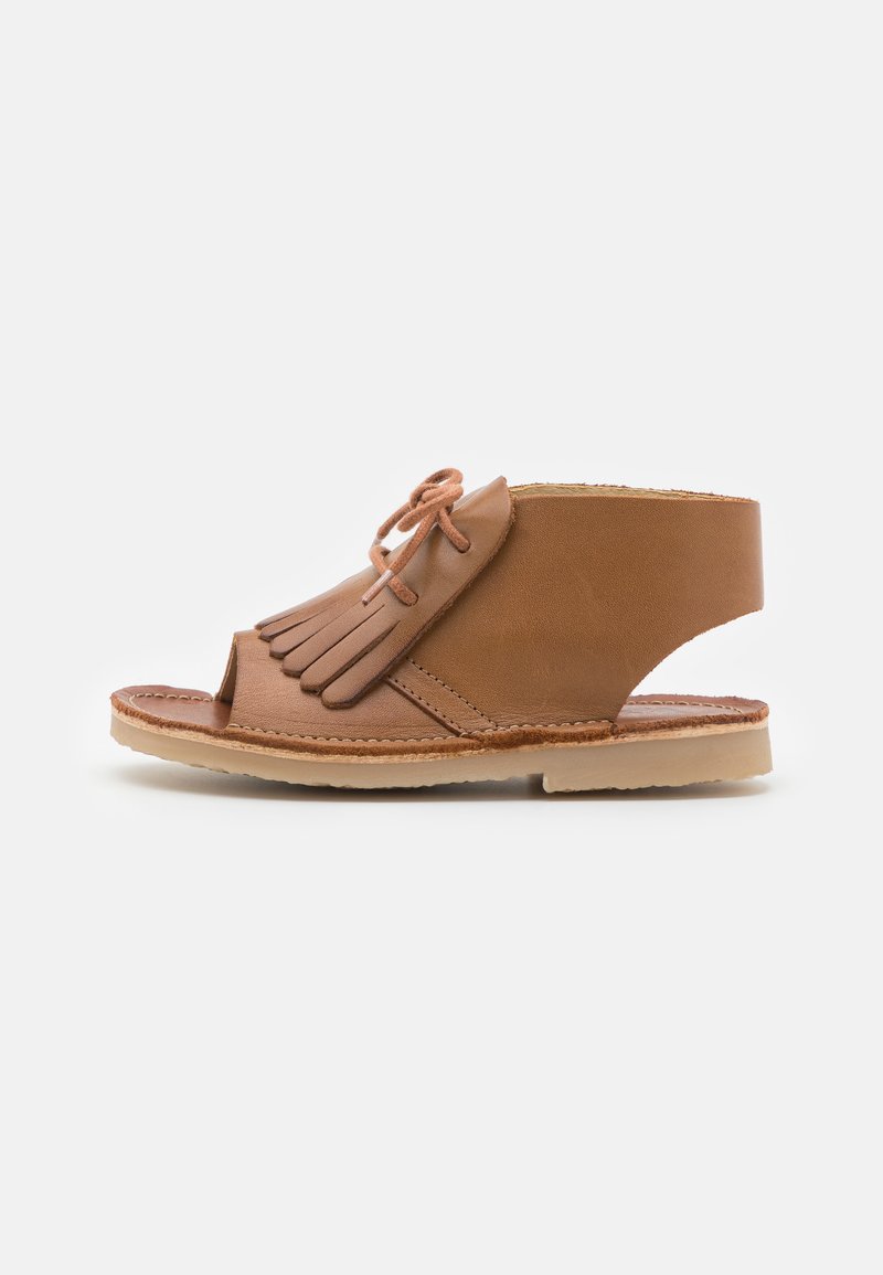 Tan lær sandaler med åpen tå og sidet utskjæring. Med frynse-detalj og snøring, plassert på en tan gummisåle.