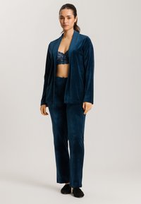 Teal velour-loungewear-set, joka sisältää pitkähihaisen avoimen neuletakin ja joustavyötäröiset housut, joissa on sileä rakenne ja rento istuvuus.