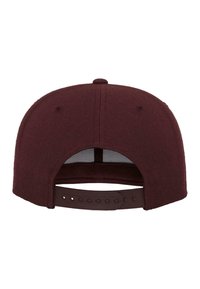 Burgundi színű baseball sapka formázott koronával, bordázott textúrájú anyagból, állítható műanyag snapback záródással és látható logók vagy minták nélkül.