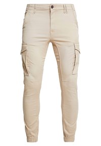 Beige cargobroek met zijzakken, taps toelopend ontwerp en elastische manchetten. Gemaakt van een lichtgewicht stof met een gladde textuur.