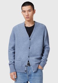 Cardigan azzurro chiaro realizzato in materiale morbido, con scollo a V, bottoni frontali, taschino sul petto e polsini a coste.
