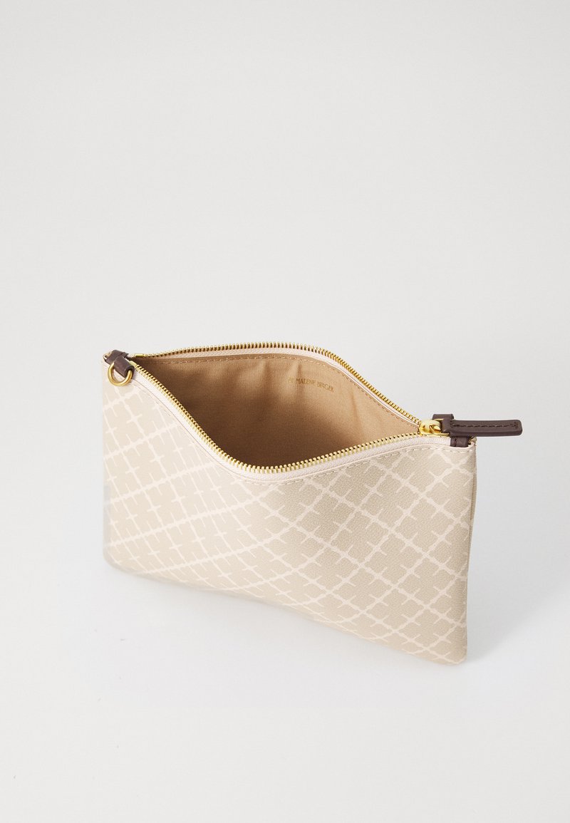 Beige Stoffbeutel mit einem gemusterten Äußeren, goldfarbenem Reißverschluss und braunem Lederakzent. Offen, zeigt ein glattes, helles Innenleben.