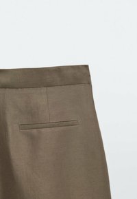 Brown linen trousers featuring a flat front, a single back pocket, and a smooth texture with a tailored fit.