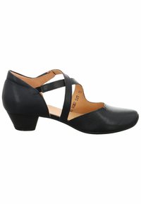 Scarpa in pelle nera con tacco basso, lati aperti e cinturini incrociati. Texture liscia con punta appuntita e dettagli di cucitura sottili.