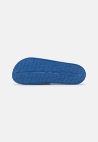 Blue rubber shoe sole with textured tread patterns for grip. Features a smooth finish and contoured shape.