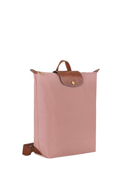 Pink nylon backpack with a brown leather flap and gold hardware. Features a top handle and adjustable shoulder strap. Minimalist design.