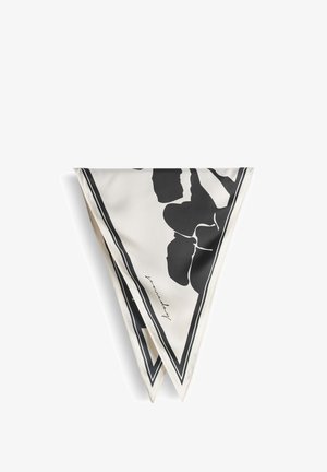 Foulard carré en soie plié en triangle, présentant des motifs floraux noirs et une signature sur un fond blanc avec une bordure noire.