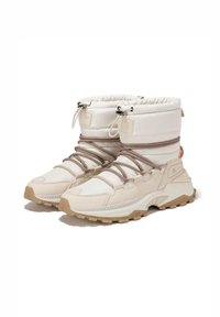 Botas impermeables beige con parte superior acolchada, aseguradas con cordones marrones, que cuentan con una suela moldeada y contrastes texturales en los materiales.