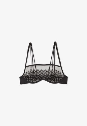 Zwarte bh met een mesh achterkant en decoratieve ronde accenten. Beschikt over verstelbare bandjes en een gestructureerd ontwerp voor ondersteuning.