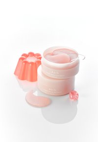 Bocaux de patchs pour les yeux Abib PDRN au rétinol roses avec des patchs en gelée texturée et un moule en gélatine rose doux. Comprend un cube de gelée ; surfaces lisses et brillantes.