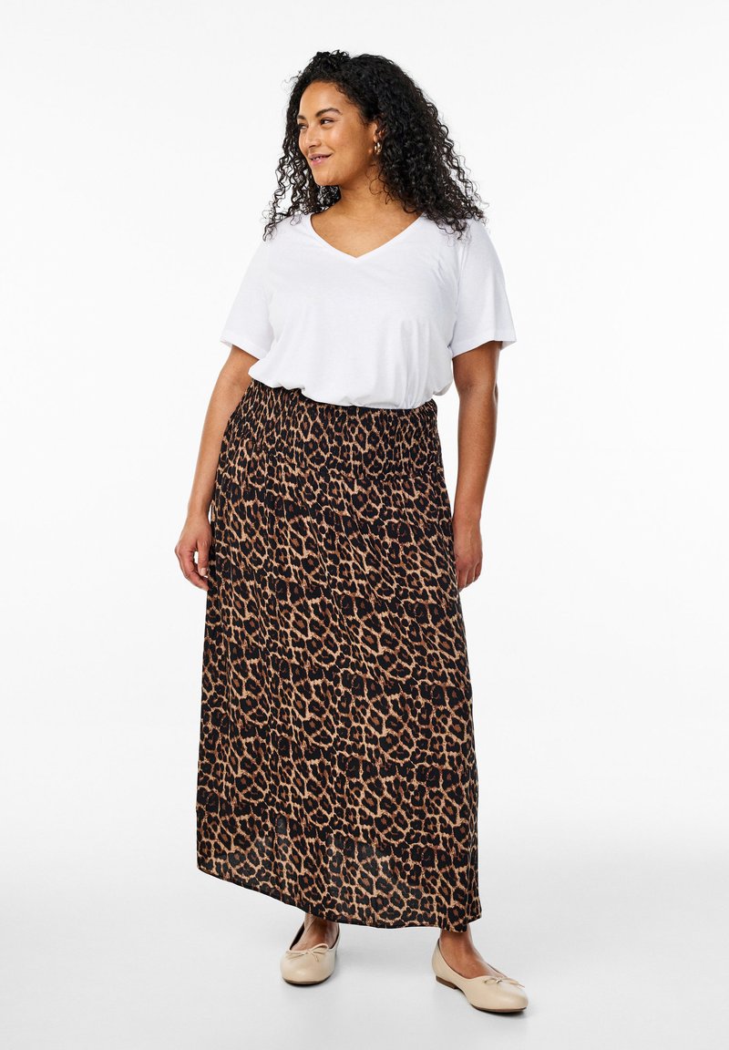 Falda maxi de estampado de leopardo con un patrón negro y marrón, cintura fruncida, combinada con una camiseta blanca de cuello en V y zapatos planos beige.