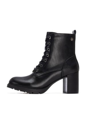 Botas de cuero negras hasta el tobillo con punta redonda, cordones en la parte delantera, tacón bloque texturizado y suela de goma con agarre. Ojetes plateados y detalle de logo.