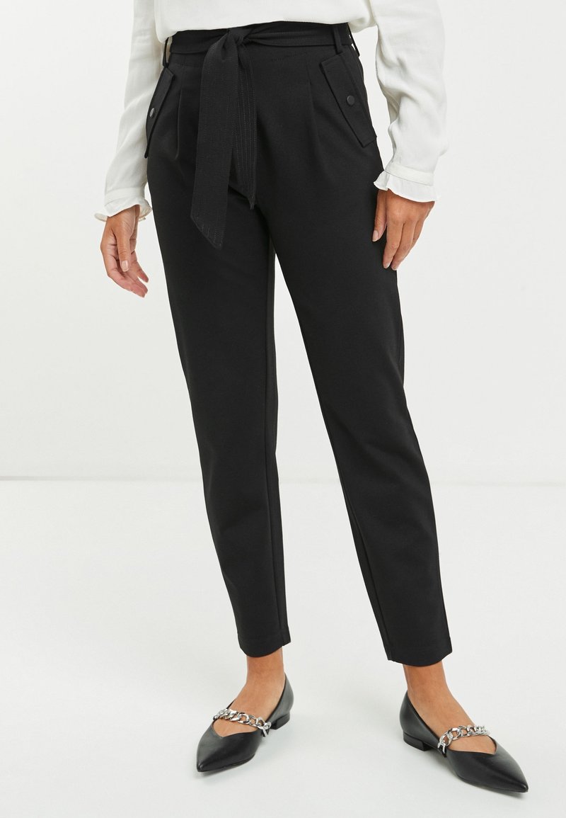 Pantalons noirs ajustés avec ceinture à nouer, dotés de poches latérales et d'une coupe slim. Texture lisse et plis nets pour un look soigné.