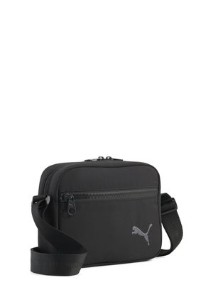 Sort rektangulær skuldertaske med lynlåslomme foran og justerbar rem, med et lille Puma-logo på forsiden.