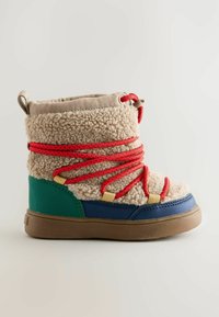Flauschiger beiger Stiefel mit roten Schnürsenkeln, grünen und blauen Akzenten sowie einer beigen Sohle. Kurzes Schaftdesign, strukturierter Schaft und gepolsterter Kragen.