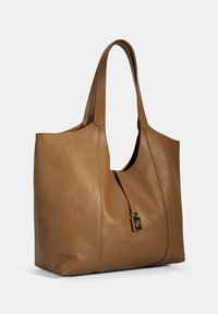 Bruine leren tote bag met een gestructureerde afwerking, verlengde handvatten, een ritssluiting met een klein slot en een ruime binnenkant.