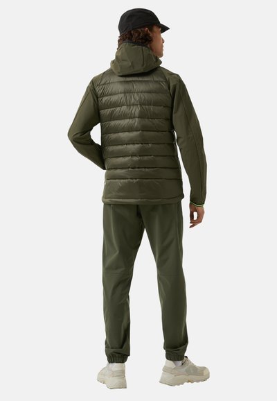 Padded olive green jacket with a hood, zippered front, and elastic cuffs, paired with matching tapered pants and light-colored sneakers.