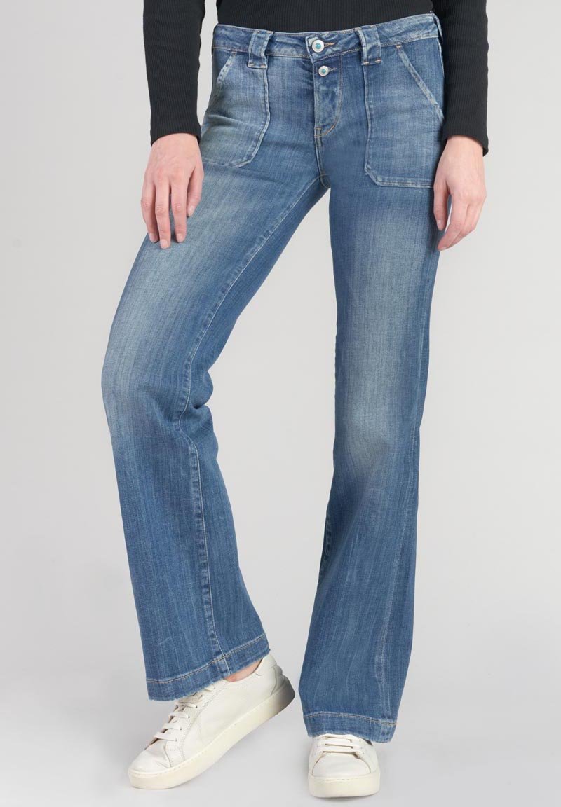 Light blue flared jeans made of denim, featuring a faded wash, dual button closure, and angled front pockets. Worn with white sneakers.