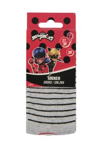 Graue Socken mit schwarzen Streifen, verpackt in einer Verpackung mit roten und schwarzen Punkten sowie Illustrationen von zwei animierten Charakteren.