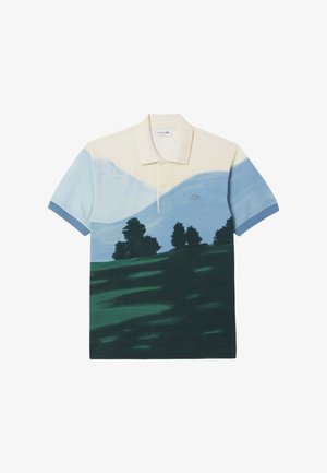 Polo con estampado de paisaje que presenta montañas y árboles. Los colores incluyen beige claro, azul y verde oscuro. Mangas cortas, cuello clásico.