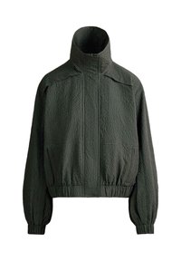 Veste noire texturée zippée avec col montant, poignets et taille élastiques, présentant un motif en forme de grille.