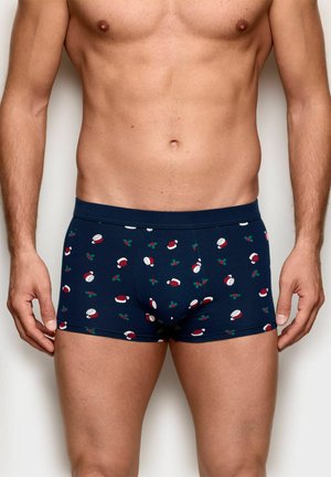 Marineblaue Boxershorts mit festlichem Muster aus roten Weihnachtsmannmützen und grünen Stechpalmenblättern, gefertigt aus weichem, dehnbarem Stoff.