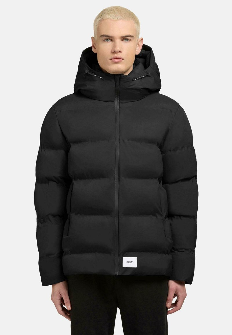 Schwarze Daunenjacke mit Reißverschluss, übergroßer Kapuze und quadratischem Logo-Patch am Saum. Hergestellt aus glattem, isoliertem Material.