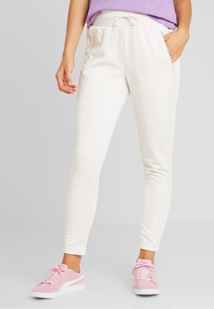 Pantaloni della tuta color beige chiaro con vita regolabile, tasche laterali e vestibilità slim. Presentano un logo sottile in bianco sulla gamba.