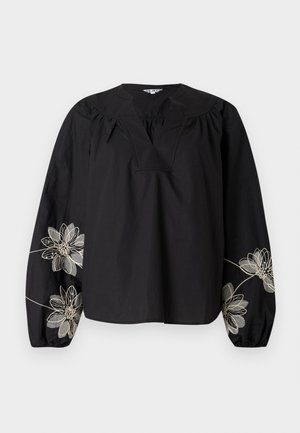 Schwarze Baumwollbluse mit tiefem Ausschnitt, langen Puffärmeln und filigraner Blumenstickerei in Gold und Weiß an den Ärmeln.