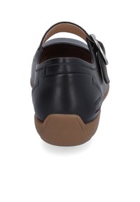 Schwarzes Leder-Schuhwerk mit geschlossenem Fersenbereich, verstellbarem Riemen und brauner Gummisohle. Verfügt über eine glatte Textur und ein minimalistisches Design.