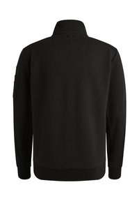 Czarny sweatshirt z teksturą plastra miodu na plecach, wysoki kołnierz i ściągacze przy mankietach. Posiada boczną kieszeń na lewym rękawie.
