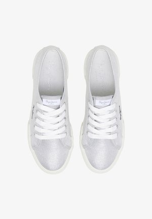 White canvas sneakers with a textured upper, rounded toe, and white laces. Features a brand logo on the side and a contrasting white sole.