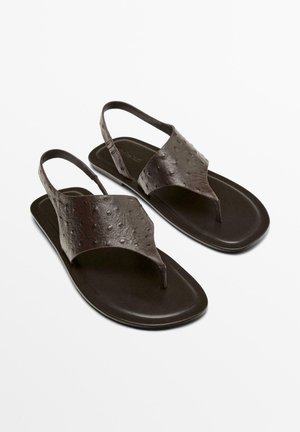 Mørkebrune læder thong-sandaler med teksturerede stropper og slingback-design på flade såler, vist side om side på hvid baggrund.