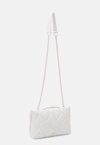 Biała pleciona torebka o gładkiej, pikowanej fakturze. Posiada podwójne uchwyty: jeden płaski i jeden łańcuchowy. Minimalistyczny design o prostokątnym kształcie.