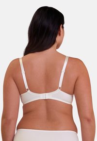 Soutien-gorge blanc avec des bretelles réglables et une fermeture à crochets dans le dos. Tissu lisse et design minimaliste, sans motifs ni embellissements.