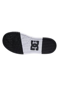 Podošva topánky s čierno-bielym dizajnom, štruktúrovaný povrch, vzorovaná priľnavosť a centrálne logo v čiernej farbe na bielej časti.