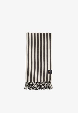 Couverture à rayures noir et blanc avec des franges en bas, fabriquée en un textile doux. Comprend une étiquette sur un côté.