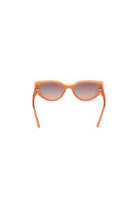 Gafas de sol de plástico naranja con lentes graduales grises. Forma de ojo de gato con brazos finos y un sutil acento metálico en las bisagras.