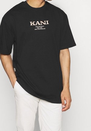 Černé bavlněné tričko s grafickým textovým designem na přední straně v béžové barvě. Tričko má volný střih a krátké rukávy.