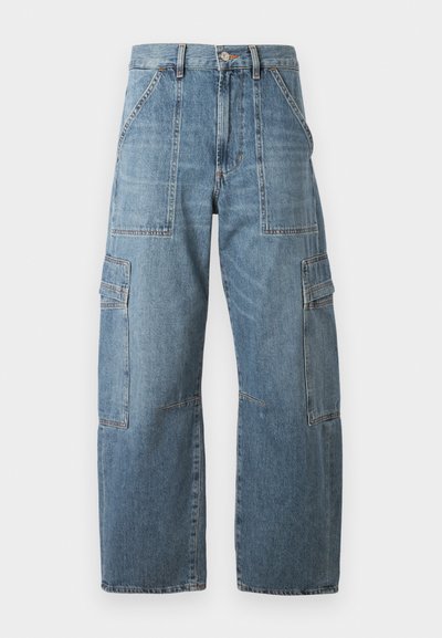 Svijetloplave traper cargo hlače sa širokim nogavicama, koje imaju više džepova, kontrastne šavove i visok struk.